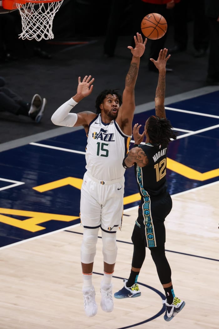 Derrick Favors (15) goes for a block against Ja Morant (12)